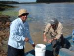FCFSA Vice President Jack De Pasquale ( left ) & FCFSA member Ian Elliot prepare to set of with buckets of Barramundi fingerlings bound for the far reaches of Lake Lenthall.